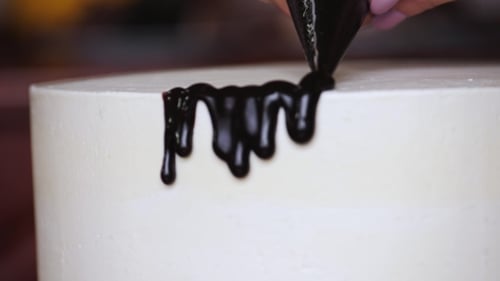 of Preparing a Sweet Cake Pouring the Chocolate Cream on It