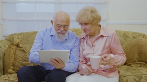 Senior Couple Using Tablet Together on Couch