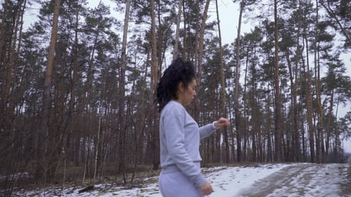 Young Woman Checks the Time During Running in the Forest