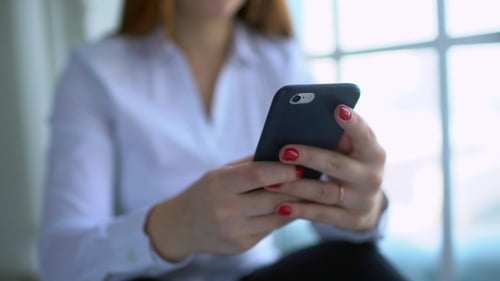 Woman's Hands Typing on a Phone Indoors
