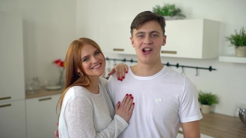 Smiling Couple Embracing in a Bright Modern Kitchen