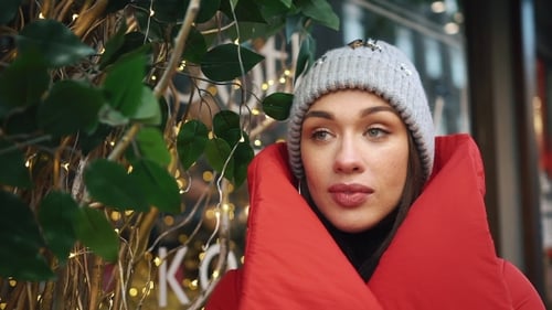 Beautiful Woman in Red Winter Jacket Walks Along the Street Covered with Snow in a Beautiful Old
