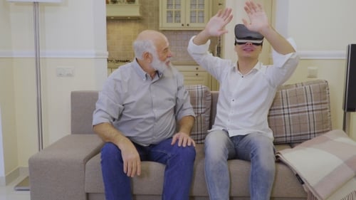 Young Adult Experiencing VR with Senior Man