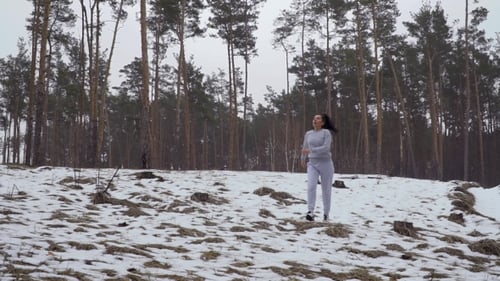 Woman Runs and Stretches in Snowy Forest Meadow