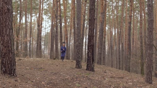 Young Beautiful Woman Is Running in the Forest