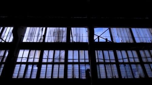 Big Glass Wall of Old Empty Building with Many of Windows, Camera Is Moving Back in Dark Space