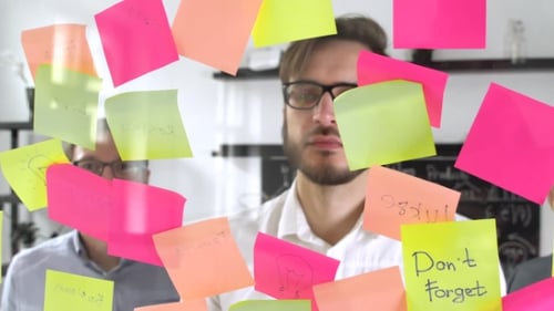 Man Post in Haftnotiz während eines Meetings im Büro, auf dem Aufkleber steht geschrieben IDEA