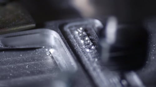In a Beautiful Light, the Drill Bit Slowly Carves Out the Aluminum Plate Company Name for