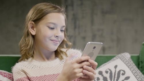 Girl Uses Smartphone in Cozy Home Setting