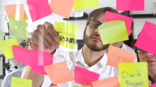 Man Post in Haftnotiz während eines Treffens im Büro auf dem Aufkleber ist geschrieben TEAM