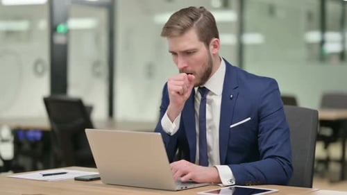 Sick Man Working on Laptop in Office