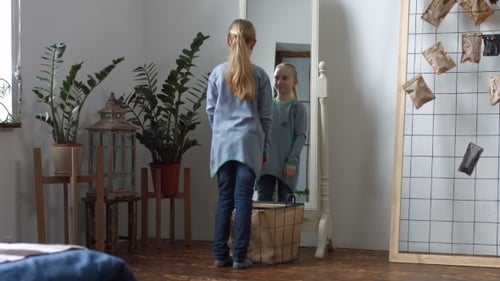 Nettes kleines Mädchen, das ihr Spiegelbild bewundert
