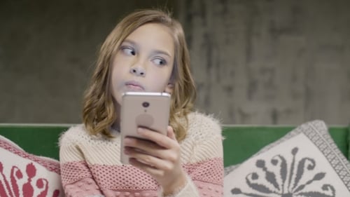 Girl on Couch Using Cell Phone Indoors