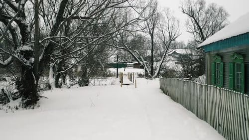Winter Village in the Snow. Old Village House and Fence in the Snow