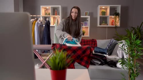 Woman Ironing Clothes at Home in Living Room