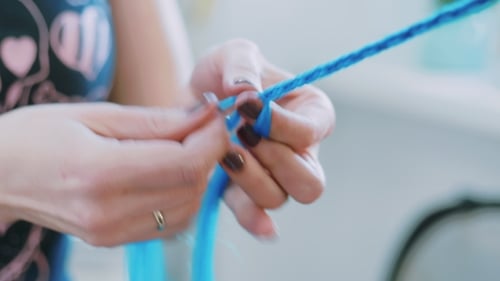 Proceso de tejido de trenzas africanas con Kanekalon. Trenzas africanas pequeñas con hebras artificiales azules