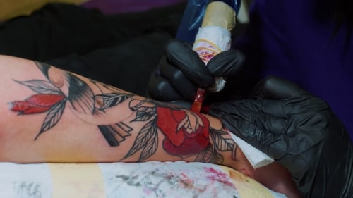Professional Master Is Painting Tattoo with Red Ink, Fills Drawing with Color
