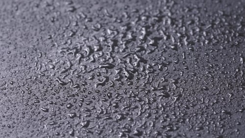 Water Droplets on Dark Textured Surface Close Up