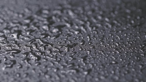 Water Drops on Black Stone Background