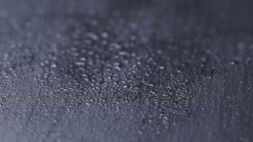 Water Drops on Black Stone Background