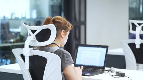 Woman Works on Laptop in the Office