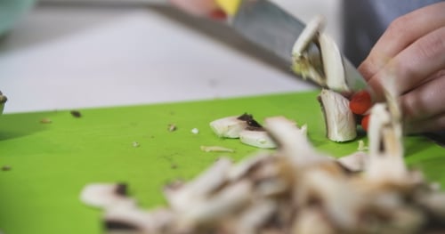Woman Dices Fresh Mushrooms with Silver Knife
