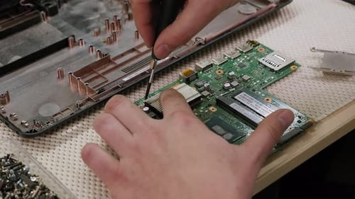 Un Homme Répare Un Ordinateur Enlève Une Carte De Circuit Électronique Sur Un Bureau