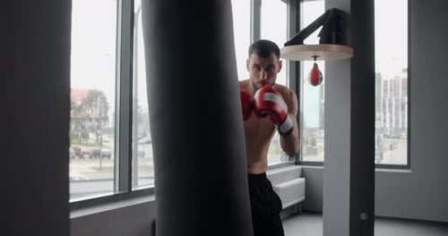 Fighter in Red Boxing Gloves Punches Boxer Bag in Slow Motion Training in Boxing Club 60p Prores HQ