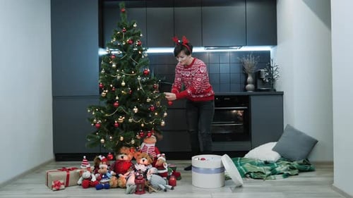 Woman Decorating Christmas Tree in Modern Home