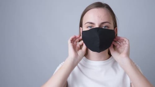 Woman Puts On a Black Face Mask