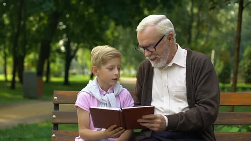 Grandfather and Child Reading Together in Park