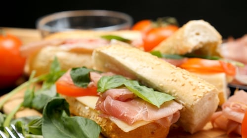 Sandwich délicieux et sain à base de prosciutto, de fromage et de tomates dans la cuisine