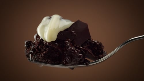 Delicious Chocolate Brownie with White Frosting on Spoon