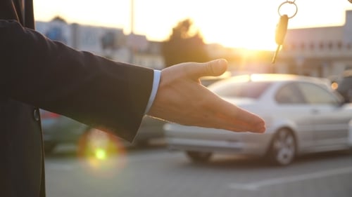 Male Hands Giving Keys of Car to His Friend. Arm of Businessman Passed Car Key