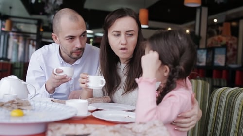 Happy Family in a Cafe Happy to Eat Pizza and Socialize with Each Other