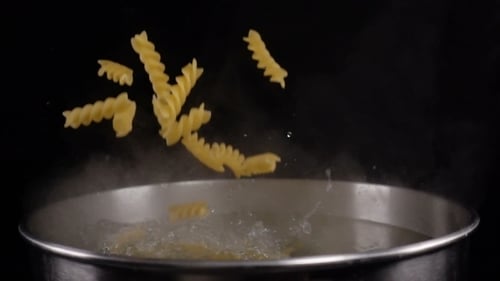 Rotini Pasta Falling into Boiling Water