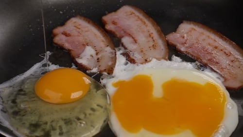 The Egg Falls on a Hot Frying Pan with Bacon
