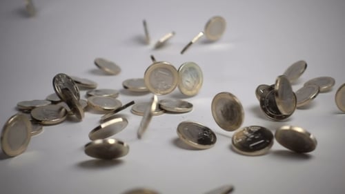 Les pièces d'un euro tombent sur un fond blanc