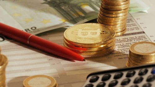 Bitcoins auf einem Bürotisch beim Ausfüllen der Steuererklärung