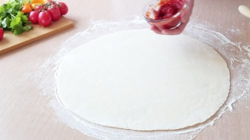 Man Prepares Tomato Sauce for Pizza