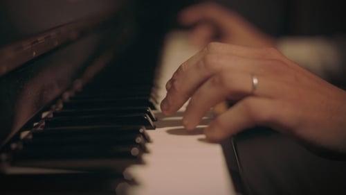 Person Playing Piano Keys Close Up