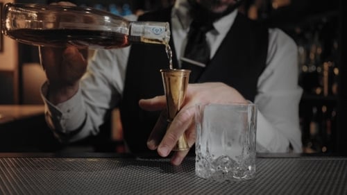 Bartender Pouring Liquor Into Jigger then Cocktail Glass
