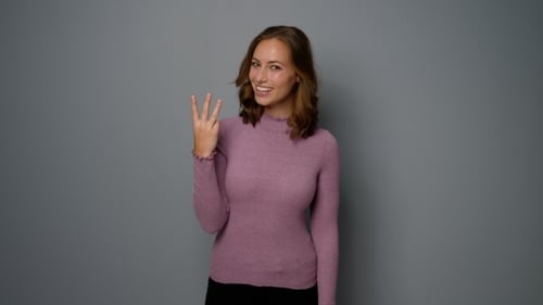 Smiling Woman Counts To Three in Studio