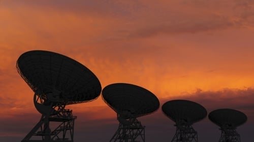 Satellite Dishes Silhouetted Against Colorful Sunset Sky