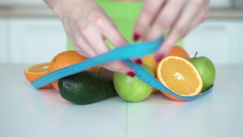 Healthy Fruits with Tape Measure on White Table