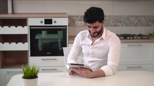 Man With Tablet Device in Kitchen