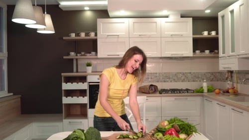 Woman Chopping Vegetables in Bright Kitchen