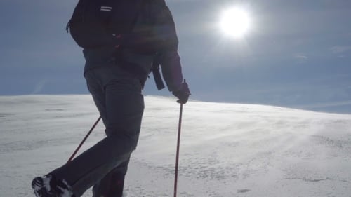 Hiker Climbs the Snow-covered Hill