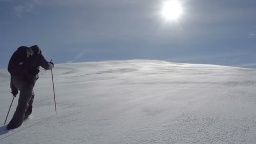 Hiker Climbs the Snow-covered Hill