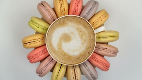 Pastel Macarons Around a Coffee Cup